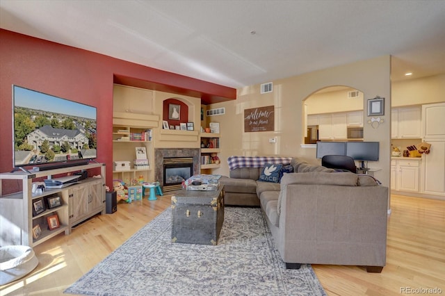 living room with a premium fireplace and light hardwood / wood-style flooring