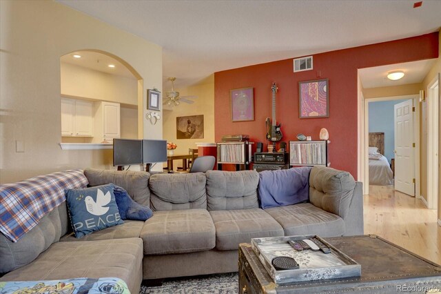 living room with light hardwood / wood-style flooring and ceiling fan