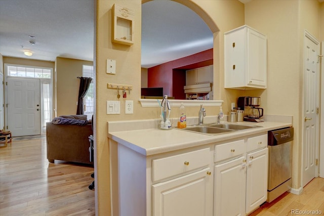 kitchen with dishwasher, sink, light wood-type flooring, white cabinetry, and a textured ceiling