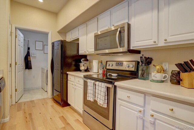 kitchen featuring washer and clothes dryer, white cabinetry, stainless steel appliances, and light hardwood / wood-style floors