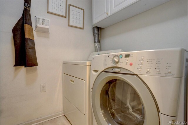 washroom featuring washing machine and dryer and cabinets