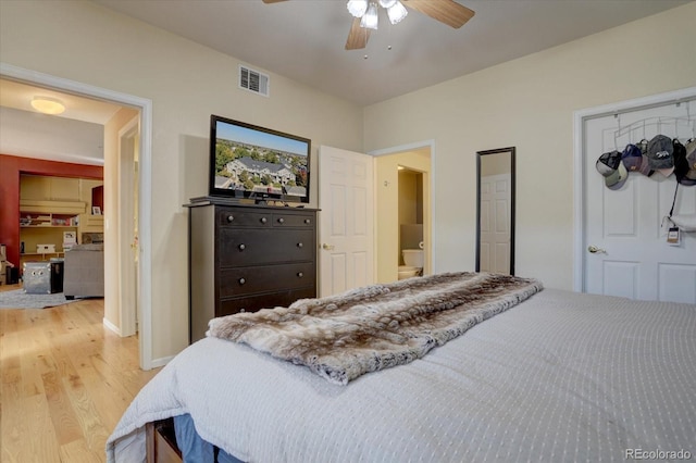 bedroom featuring light hardwood / wood-style floors, ensuite bathroom, and ceiling fan