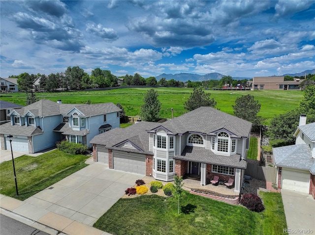 1825 Keota Ln, Superior, CO 80027 - view of front of house featuring an attached garage, brick siding, driveway, a mountain view, and roof with shingles