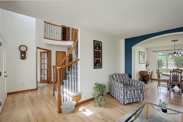 1825 Keota Ln, Superior, CO 80027 - living area with arched walkways, light wood finished floors, baseboards, stairway, and a chandelier
