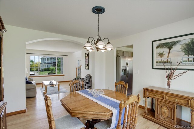 1825 Keota Ln, Superior, CO 80027 - dining area featuring arched walkways, light wood finished floors, baseboards, and a chandelier