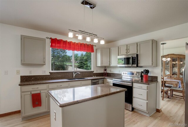 1825 Keota Ln, Superior, CO 80027 - kitchen with stainless steel appliances, a sink, light wood-type flooring, a center island, and hanging light fixtures