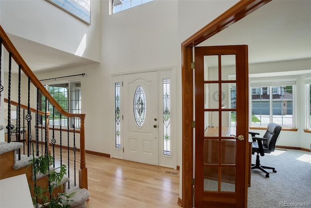 1825 Keota Ln, Superior, CO 80027 - foyer entrance featuring baseboards, stairs, light wood-style floors, and a towering ceiling
