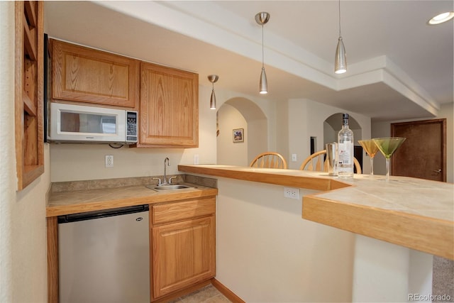 1825 Keota Ln, Superior, CO 80027 - kitchen with refrigerator, white microwave, a sink, hanging light fixtures, and arched walkways