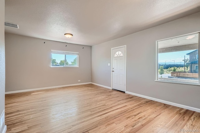 4804 N Raleigh St, Denver, CO 80212 - empty room with plenty of natural light, light wood-style floors, and a textured ceiling