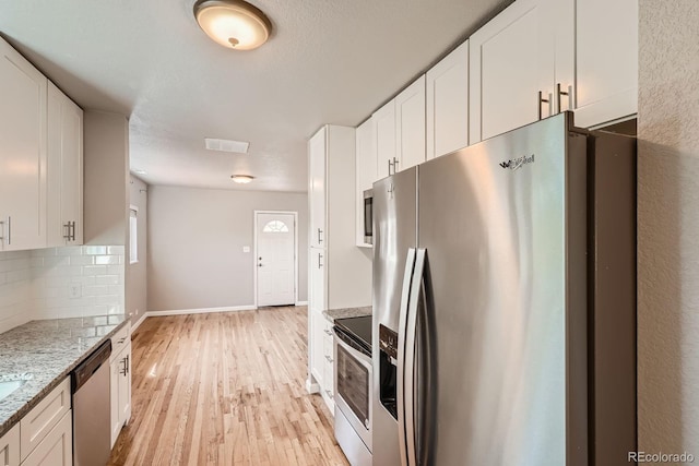 4804 N Raleigh St, Denver, CO 80212 - kitchen featuring appliances with stainless steel finishes, white cabinets, and decorative backsplash