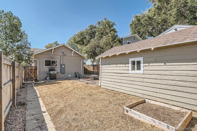 4804 N Raleigh St, Denver, CO 80212 - back of property featuring a fenced backyard, a vegetable garden, a gate, and roof with shingles