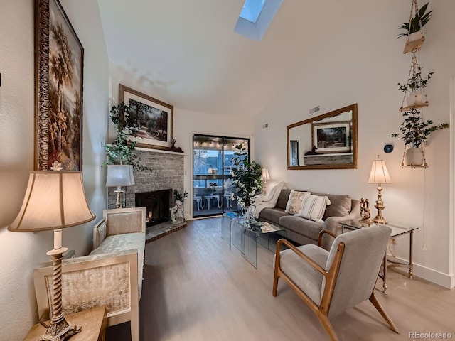 living area featuring visible vents, lofted ceiling with skylight, wood finished floors, a fireplace, and baseboards