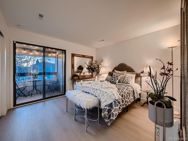 bedroom featuring access to exterior and wood finished floors