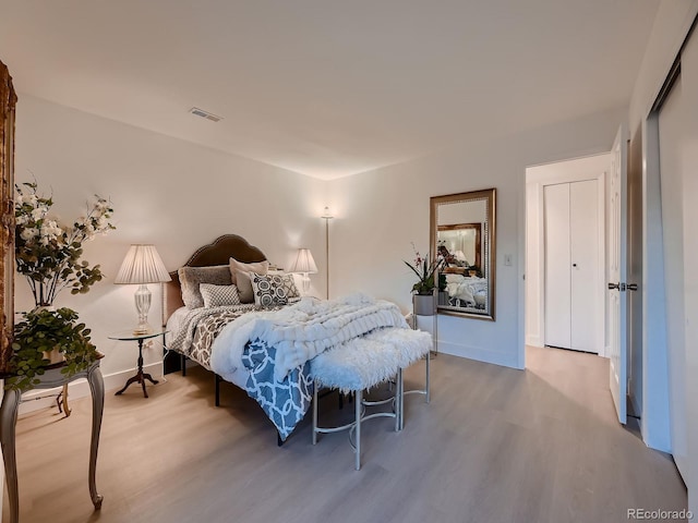 bedroom featuring visible vents, baseboards, and wood finished floors