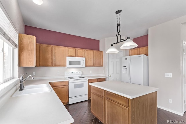 kitchen featuring decorative light fixtures, sink, a center island, and white appliances