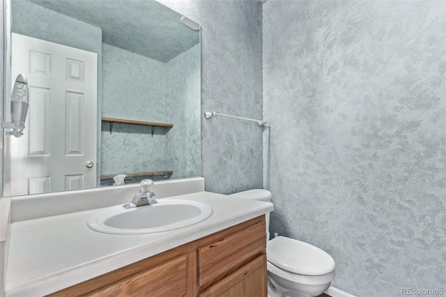 bathroom featuring toilet and vanity