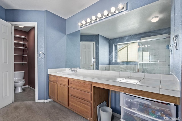 bathroom with a shower with shower door, vanity, beverage cooler, and toilet