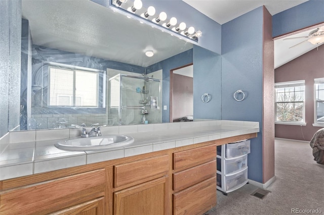 bathroom featuring ceiling fan, vanity, and walk in shower