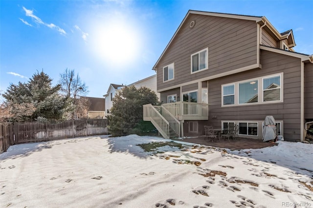 snow covered rear of property featuring a patio area