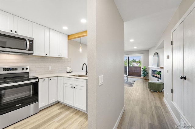 4274 S Salida Way Unit 3, Aurora, CO 80013 - kitchen with stainless steel appliances, a sink, backsplash, light wood finished floors, and recessed lighting