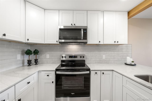 4274 S Salida Way Unit 3, Aurora, CO 80013 - kitchen featuring appliances with stainless steel finishes, white cabinets, decorative backsplash, and light stone countertops