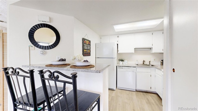 8701 Huron St Unit 1-207, Thornton, CO 80260 - kitchen featuring white appliances, a sink, light wood-style floors, white cabinets, and light countertops