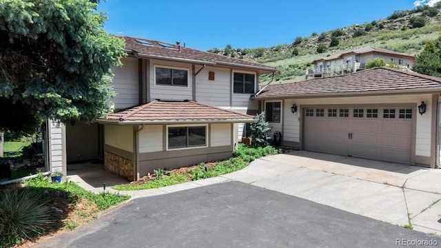 view of front facade featuring a mountain view, driveway, and an attached garage