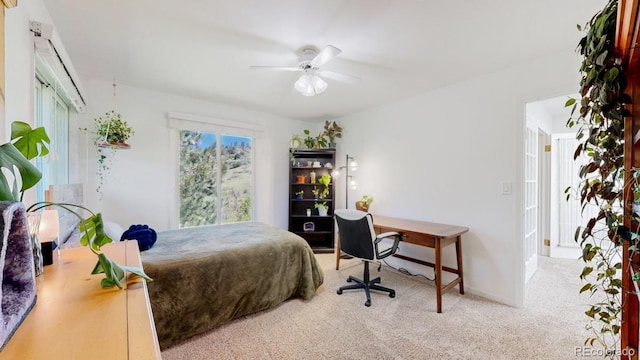 bedroom featuring carpet flooring, an office area, and a ceiling fan
