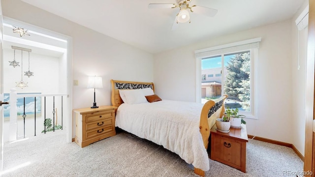 bedroom featuring light carpet, baseboards, and a ceiling fan