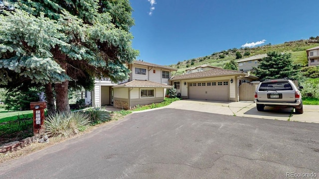 view of front of property featuring an attached garage, asphalt driveway, and a mountain view