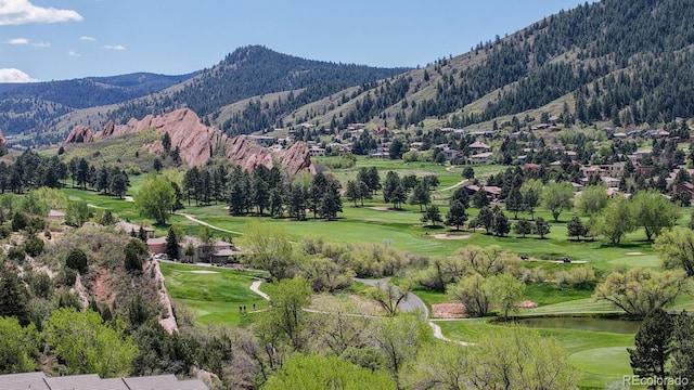 view of mountain backdrop featuring a nearby body of water and a golf club