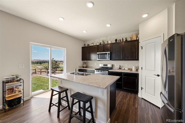 kitchen with dark hardwood / wood-style flooring, a kitchen breakfast bar, plenty of natural light, and stainless steel appliances