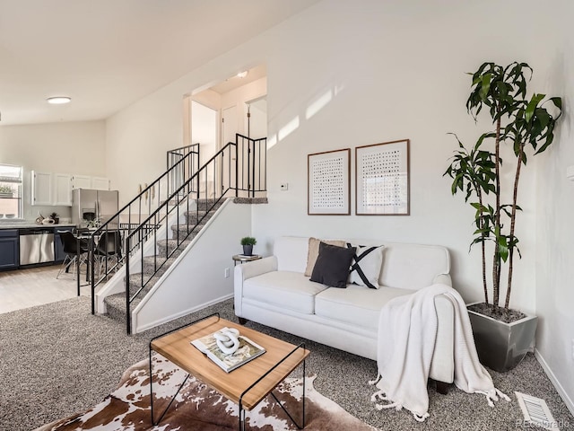 living room featuring lofted ceiling and carpet