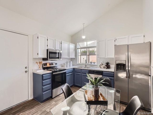 kitchen featuring stainless steel appliances, white cabinetry, sink, and blue cabinets