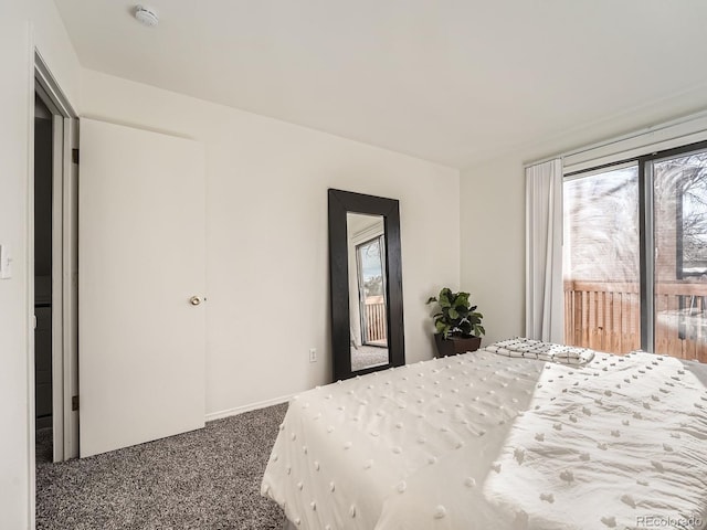 bedroom featuring access to exterior and dark colored carpet