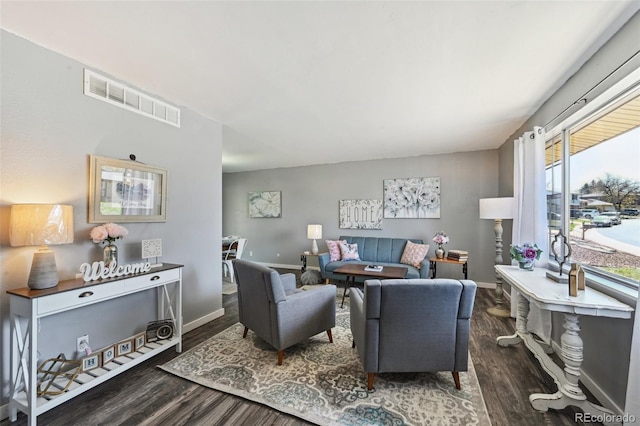 living area with visible vents, baseboards, and wood finished floors