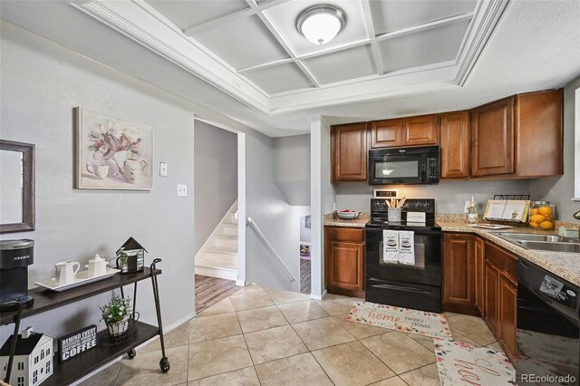 kitchen with brown cabinets, a sink, black appliances, coffered ceiling, and light tile patterned flooring