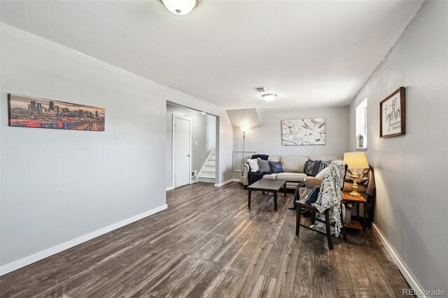 living room with dark wood-type flooring, stairs, baseboards, and visible vents
