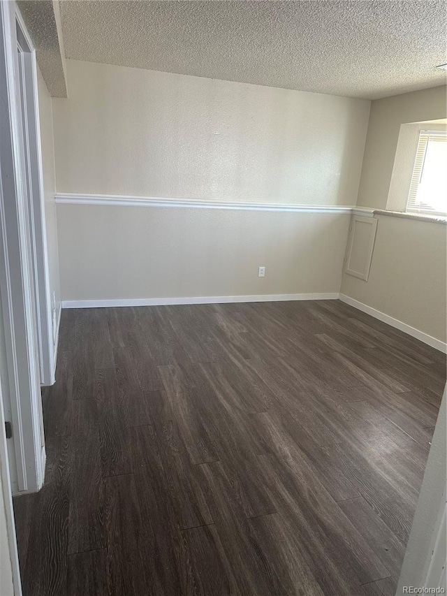 unfurnished room featuring dark hardwood / wood-style floors and a textured ceiling