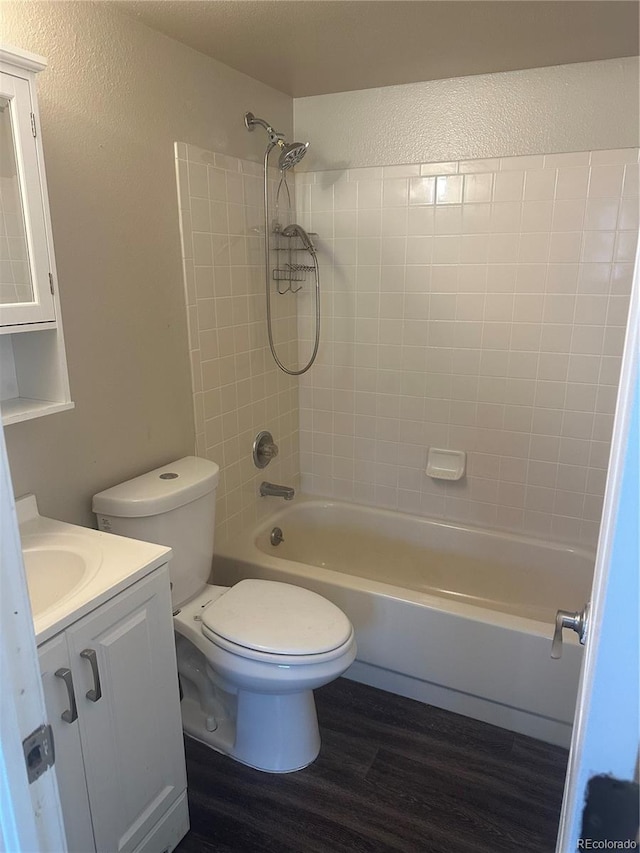 full bathroom with vanity, toilet, tiled shower / bath combo, and hardwood / wood-style floors