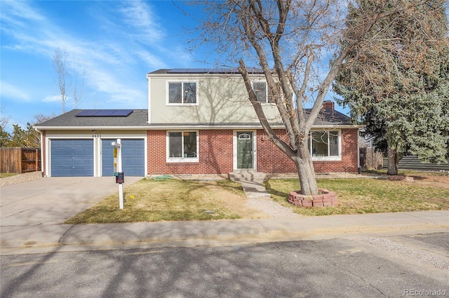 view of front of home with a front yard, fence, an attached garage, concrete driveway, and brick siding