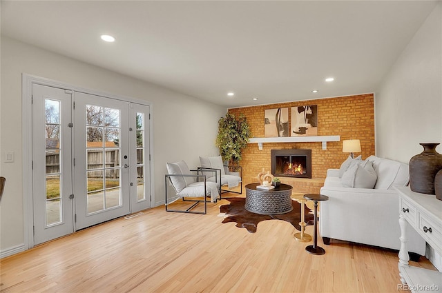 living area with recessed lighting, a fireplace, and light wood finished floors