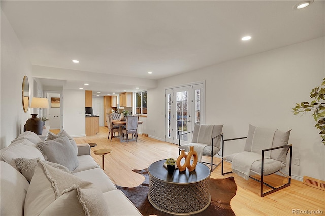 living room featuring baseboards, recessed lighting, visible vents, and light wood-type flooring