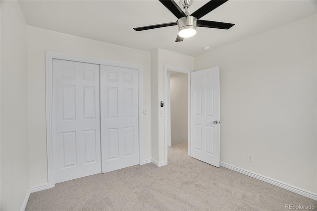 unfurnished bedroom featuring light carpet, baseboards, a closet, and a ceiling fan