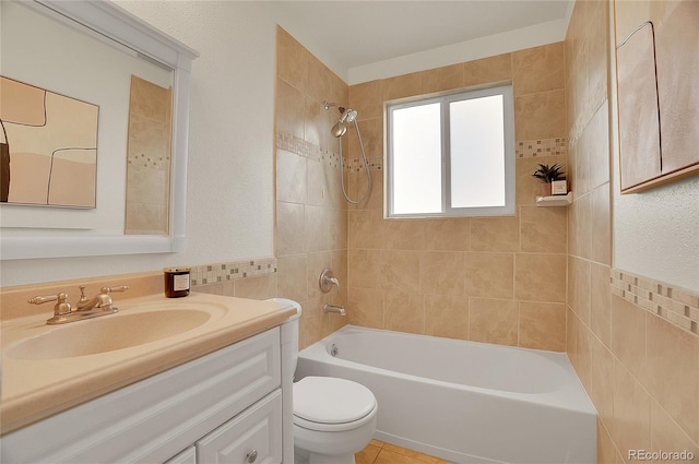 full bath with toilet, tile walls,  shower combination, tile patterned flooring, and vanity