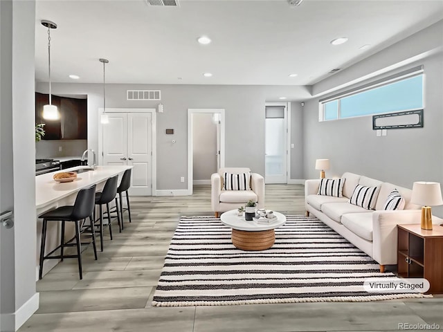 1245 Utica St Unit 104, Denver, CO 80204 - living area featuring light wood-style flooring and recessed lighting
