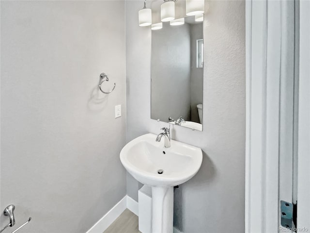 1245 Utica St Unit 104, Denver, CO 80204 - bathroom featuring baseboards and wood finished floors