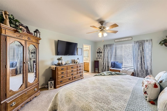 bedroom with ensuite bathroom, ceiling fan, and light colored carpet