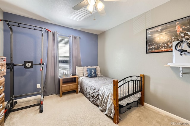 bedroom featuring ceiling fan, light colored carpet, and a textured ceiling