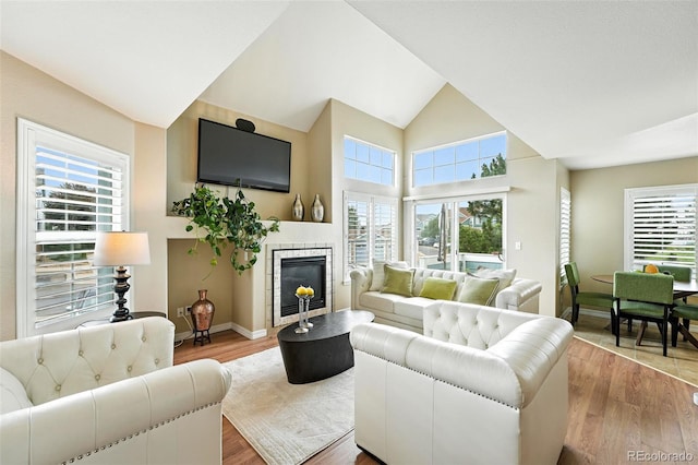 2567 Cutters Cir Unit 101, Castle Rock, CO 80108 - living area featuring plenty of natural light, wood finished floors, a tile fireplace, and high vaulted ceiling